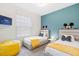 Charming bedroom with twin beds, Disney decor, natural light from the window, and a bright yellow beanbag chair at 8879 Geneve Ct, Kissimmee, FL 34747