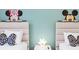 Charming bedroom with twin beds, Disney decor, and a playful atmosphere at 8879 Geneve Ct, Kissimmee, FL 34747