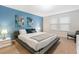 Inviting primary bedroom featuring a comfortable bed, calming blue accent wall, and ample natural light at 8879 Geneve Ct, Kissimmee, FL 34747