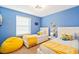 Bright and cheerful bedroom featuring twin beds, Minion decor, and a cozy yellow beanbag chair at 8879 Geneve Ct, Kissimmee, FL 34747