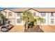 Charming townhouse with a well-manicured front yard featuring palm trees and ample parking space at 8879 Geneve Ct, Kissimmee, FL 34747