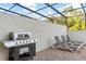Covered patio area featuring a built-in grill and comfortable lounge seating, ideal for outdoor gatherings at 8879 Geneve Ct, Kissimmee, FL 34747