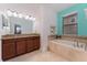 Bright bathroom with tiled floor, granite countertop, soaking tub, and blue accent wall at 8924 Azalea Sands Ln # 8924, Davenport, FL 33896