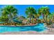 Community lazy river with bridge and waterslide surrounded by lush, tropical landscaping at 8924 Azalea Sands Ln # 8924, Davenport, FL 33896