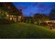 Expansive backyard with mature landscaping, a boathouse, and outdoor seating, perfect for evening relaxation at 9212 Island Lake Ct, Orlando, FL 32836