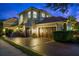 Elegant two-story home with a terracotta roof, a two-car garage, and well-manicured landscaping at twilight at 9212 Island Lake Ct, Orlando, FL 32836