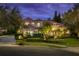 Elegant two-story home featuring a red tile roof, manicured landscaping, and decorative outdoor lighting at 9212 Island Lake Ct, Orlando, FL 32836