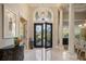 Elegant foyer featuring marble floors, soaring ceilings, an ornate chandelier, and a wrought iron front door at 9212 Island Lake Ct, Orlando, FL 32836