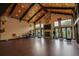 Spacious home gym with high ceilings, exposed beams, a stone fireplace, a TV, and exercise equipment at 9212 Island Lake Ct, Orlando, FL 32836