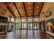 Large home gym featuring exposed beams, vaulted ceilings, a stone fireplace, exercise equipment, and pool views at 9212 Island Lake Ct, Orlando, FL 32836