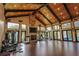 Expansive home gym with vaulted ceilings, exposed beams, natural light, stone fireplace, and exercise equipment at 9212 Island Lake Ct, Orlando, FL 32836