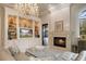 Cozy living room with a fireplace, built-in shelving, and comfortable seating under a decorative chandelier at 9212 Island Lake Ct, Orlando, FL 32836