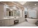 Spa-like main bathroom with double vanities, a soaking tub, a fireplace, and elegant lighting fixtures at 9212 Island Lake Ct, Orlando, FL 32836