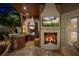 Covered outdoor kitchen with stone countertops, a fireplace with a TV, and comfortable seating at 9212 Island Lake Ct, Orlando, FL 32836