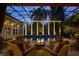 Luxury pool area with a fire pit, covered seating, a screened enclosure, and elegant columns at 9212 Island Lake Ct, Orlando, FL 32836