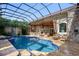 Enclosed pool area with an outdoor kitchen, bar seating, waterfall features, and a screened enclosure at 9212 Island Lake Ct, Orlando, FL 32836