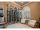 This stylish wine room boasts an arched window, marble floors, and a floor-to-ceiling glass enclosed wine rack at 9212 Island Lake Ct, Orlando, FL 32836