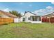 Backyard featuring an enclosed patio, shed, red fence, and a lush lawn at 9868 Flynt Cir, Orlando, FL 32825