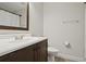 Bathroom featuring a stylish vanity with dark wood cabinets, mirror, and a toilet at 10525 Satinwood Cir, Orlando, FL 32825