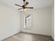 Bright bedroom featuring a ceiling fan, wood-look floors, and a window with natural light at 10525 Satinwood Cir, Orlando, FL 32825