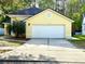 Charming, light-yellow single story home with a well-manicured lawn and a two car garage at 10525 Satinwood Cir, Orlando, FL 32825