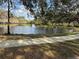 Scenic view of a pond with a fountain, surrounded by lush greenery and a walkway at 10525 Satinwood Cir, Orlando, FL 32825