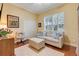 Bright bedroom with wood floors, white sofa, ottoman, and plantation shutters at 10819 Woodchase Circle, Orlando, FL 32836