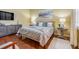 Bedroom featuring neutral walls, wood floors, upholstered headboard and two bedside tables at 10819 Woodchase Circle, Orlando, FL 32836