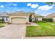 Charming one-story home with a brick driveway, well manicured lawn, and a beige tile roof at 10819 Woodchase Circle, Orlando, FL 32836