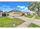 Street view showcasing the home with manicured lawn, brick driveway, and beige tile roof at 10819 Woodchase Circle, Orlando, FL 32836