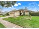 Beautiful one-story home with well-kept lawn, brick driveway, and a beige tile roof at 10819 Woodchase Circle, Orlando, FL 32836