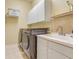 Efficient laundry room with modern washer and dryer, sink, and overhead cabinets at 10819 Woodchase Circle, Orlando, FL 32836