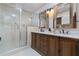 Well-lit bathroom boasting a glass enclosed shower and dark wood double sink vanity at 111 Autumn Dr, Longwood, FL 32779