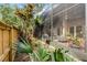 View of screened patio with cozy seating area reflected in screen, framed by lush landscaping and wooden fence at 111 Autumn Dr, Longwood, FL 32779