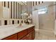 Elegant bathroom featuring striped wallpaper, wood cabinets, white countertop, and tiled floor at 1141 Sweet Heather Ln, Apopka, FL 32712