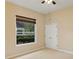 Simple bedroom with carpet, ceiling fan, and a window view of the greenery outside at 1141 Sweet Heather Ln, Apopka, FL 32712