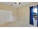 Carpeted bedroom featuring a ceiling fan, double door closet, and a window with blue curtains at 1141 Sweet Heather Ln, Apopka, FL 32712