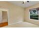 Minimalist bedroom with neutral carpet and paint, a window, and a ceiling fan at 1141 Sweet Heather Ln, Apopka, FL 32712