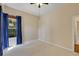 Neutral bedroom with carpet, ceiling fan, natural light, and a window with blue curtains at 1141 Sweet Heather Ln, Apopka, FL 32712