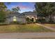 Charming home featuring an inviting entrance, manicured lawn, arched entryway, and mature landscaping at 1141 Sweet Heather Ln, Apopka, FL 32712