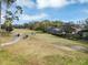 Picturesque golf course view with golfers near a home featuring a screened-in porch in the background at 1141 Sweet Heather Ln, Apopka, FL 32712