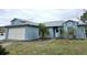 Inviting one-story home with an attached two-car garage, landscaped front yard with mature trees and sidewalk entry at 11500 Brandiwine Ct, Clermont, FL 34711