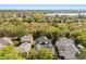 Drone shot of the property surrounded by lush greenery, neighboring homes and a lake in the distance at 11521 Camden Park Dr, Windermere, FL 34786