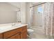 Bright bathroom with white tiled shower-tub, floral shower curtain and wood vanity with white sink at 11521 Camden Park Dr, Windermere, FL 34786