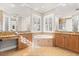 Spa-like bathroom with double vanity, soaking tub, and large windows with plantation shutters at 11521 Camden Park Dr, Windermere, FL 34786