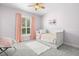 Comfortable bedroom with soft pink accents, including curtains and a cozy throw pillow at 11521 Camden Park Dr, Windermere, FL 34786