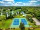 Aerial view of a community featuring tennis courts, a swimming pool, a lake, and tree coverage at 142 Long Leaf Pine Cir, Sanford, FL 32773