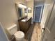 Bathroom with dual sink vanity, mirrors, and toilet at 142 Long Leaf Pine Cir, Sanford, FL 32773