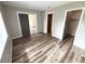 Bedroom featuring wood-look floors, sliding doors and multiple doorways, enhancing spacious feel at 142 Long Leaf Pine Cir, Sanford, FL 32773