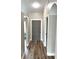 Hallway with hardwood floors leading to a gray door and other rooms at 142 Long Leaf Pine Cir, Sanford, FL 32773